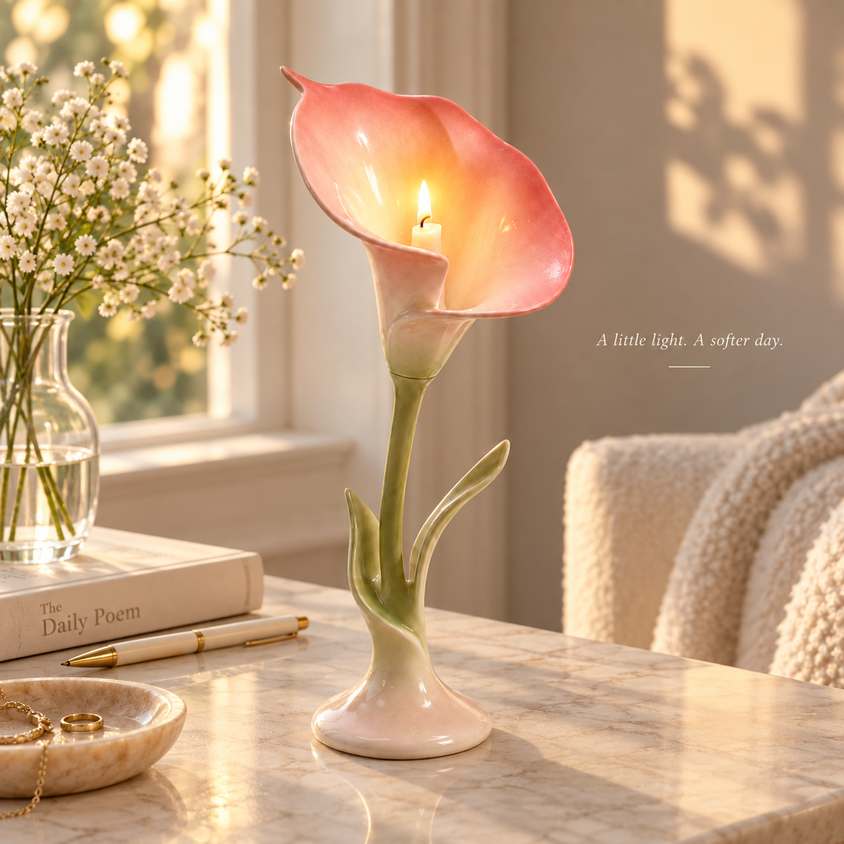 Lit ceramic calla lily candle holder styled on a warm sunlit reading table.