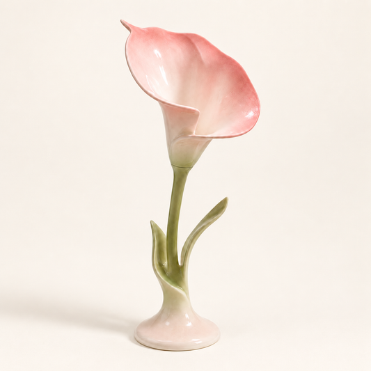 Blush pink ceramic calla lily candle holder with sage green stem on a warm ivory background.